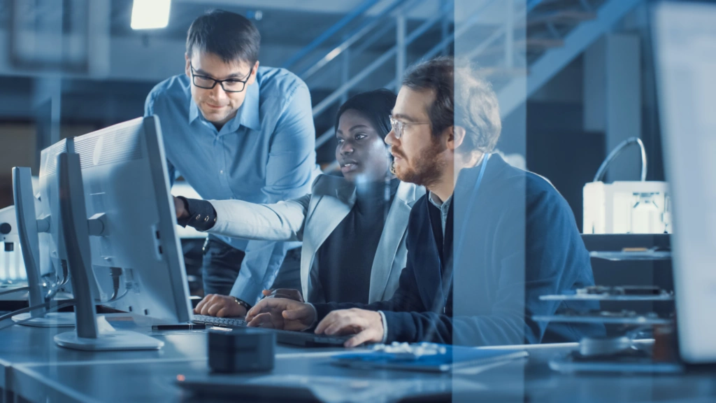 IT professionals working on Descartes export license management software, with compliance specialist and logistics manager.